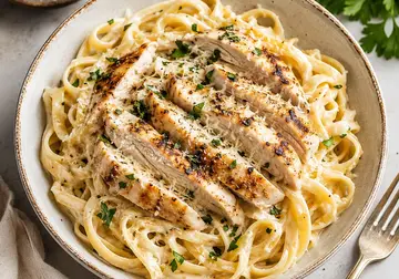Creamy tagliatelle topped with sliced chicken, Parmesan and parsley